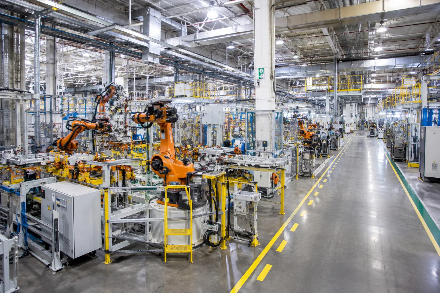 Smart manufacturing production line showing robotic assembly arm and industrial predictive maintenance sensors